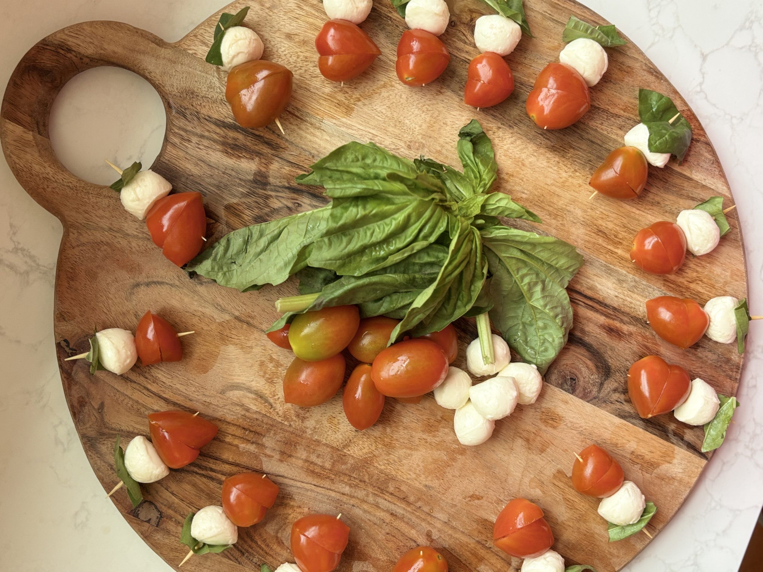 cutting board covered in Caprese salad bites