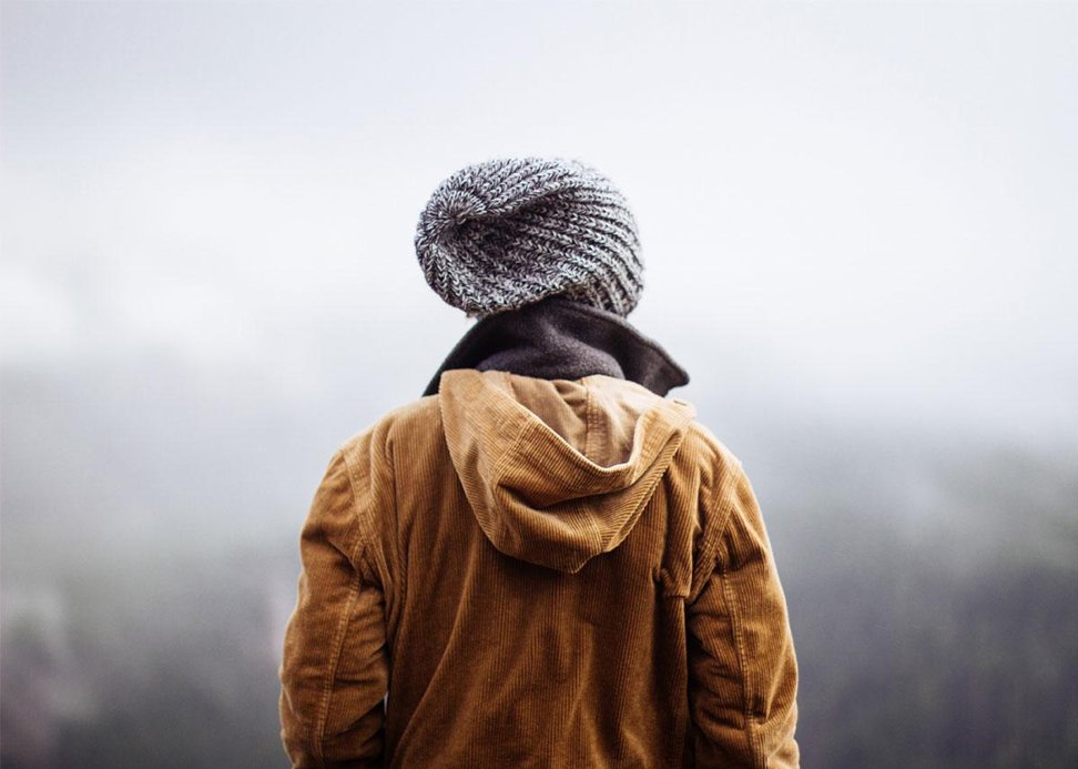 woman standing at a high elevation looking into the clouds