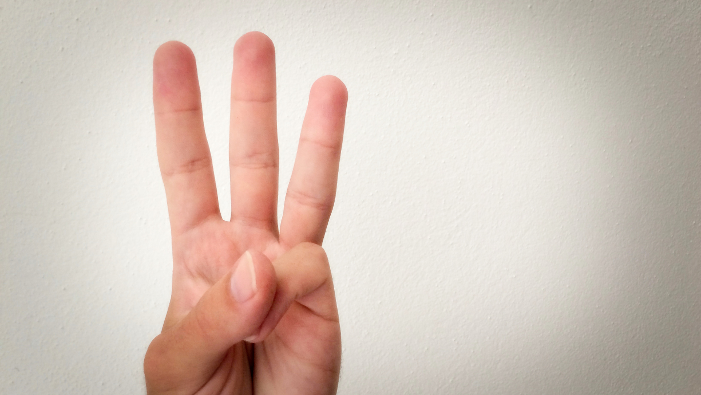 Hand holding up three fingers