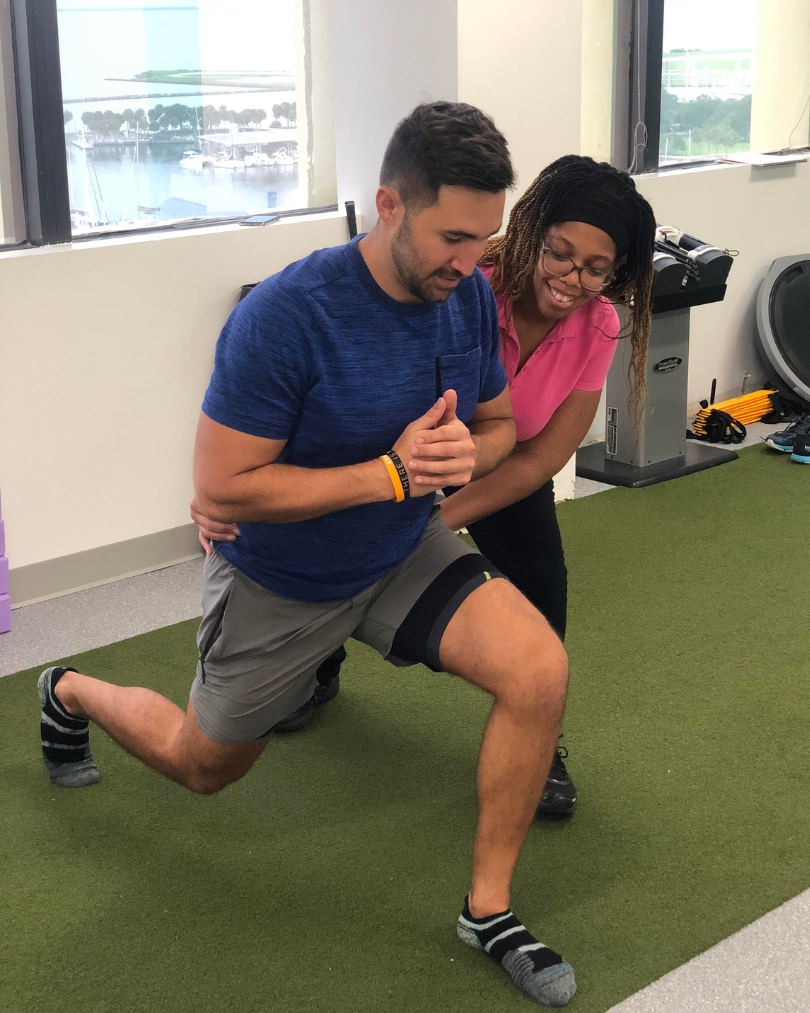 Physio helping a patient through a lunge movement