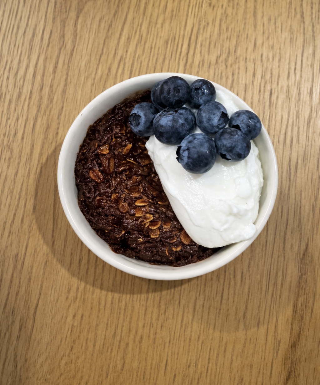 Bowl of baked oats with yogurt and berries on top