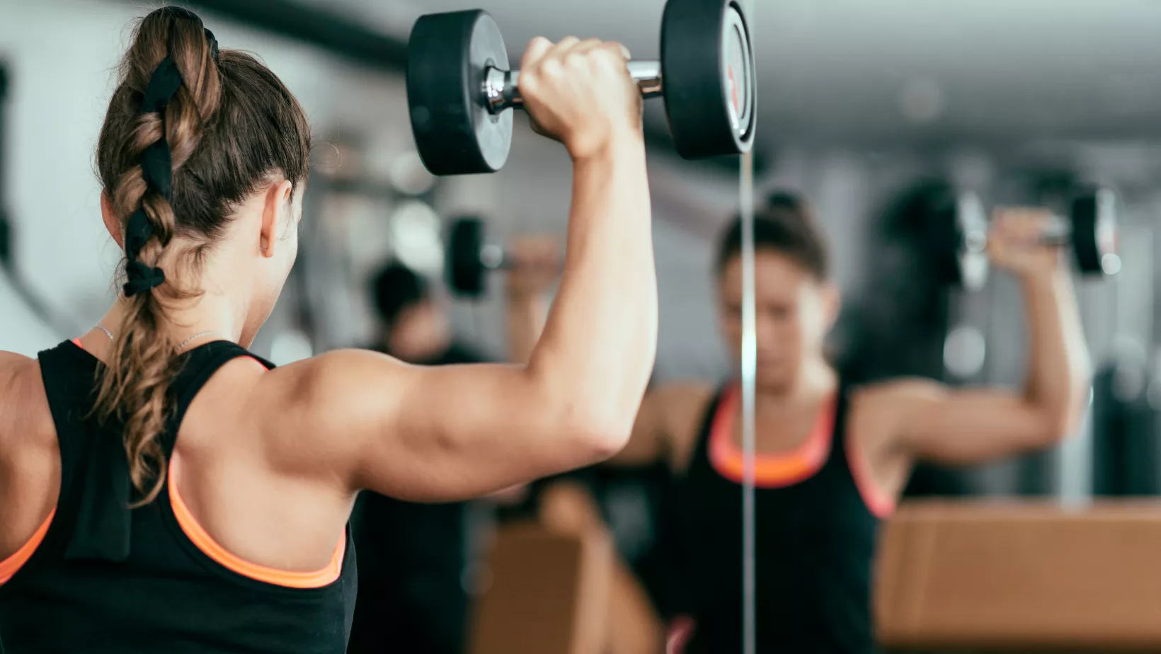 woman lifting weights overhead