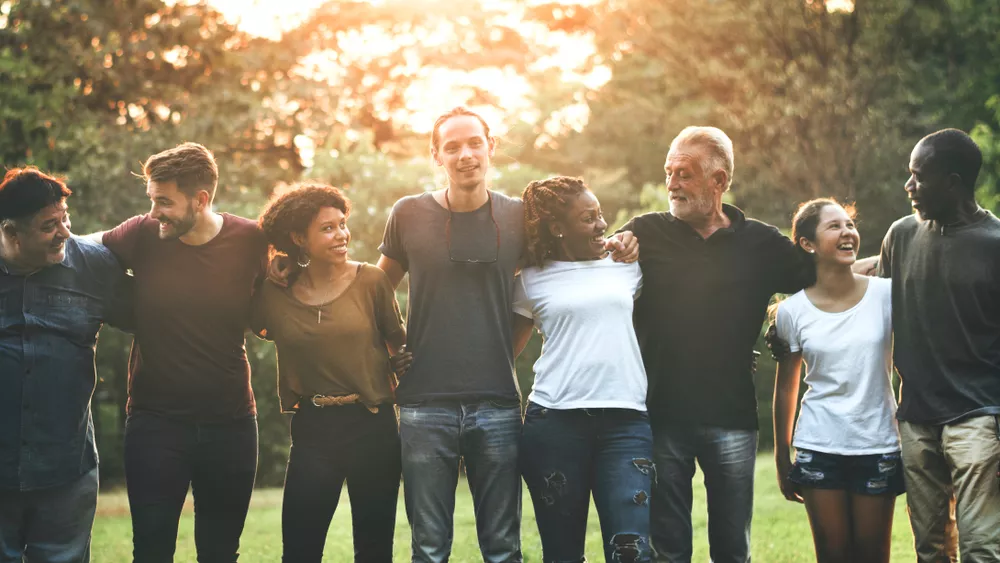 Group of colleagues in a row at the park, linked arm in arm