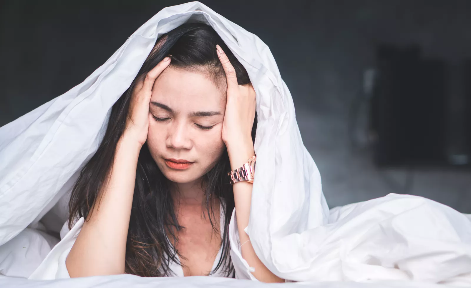 Woman in bed with headache