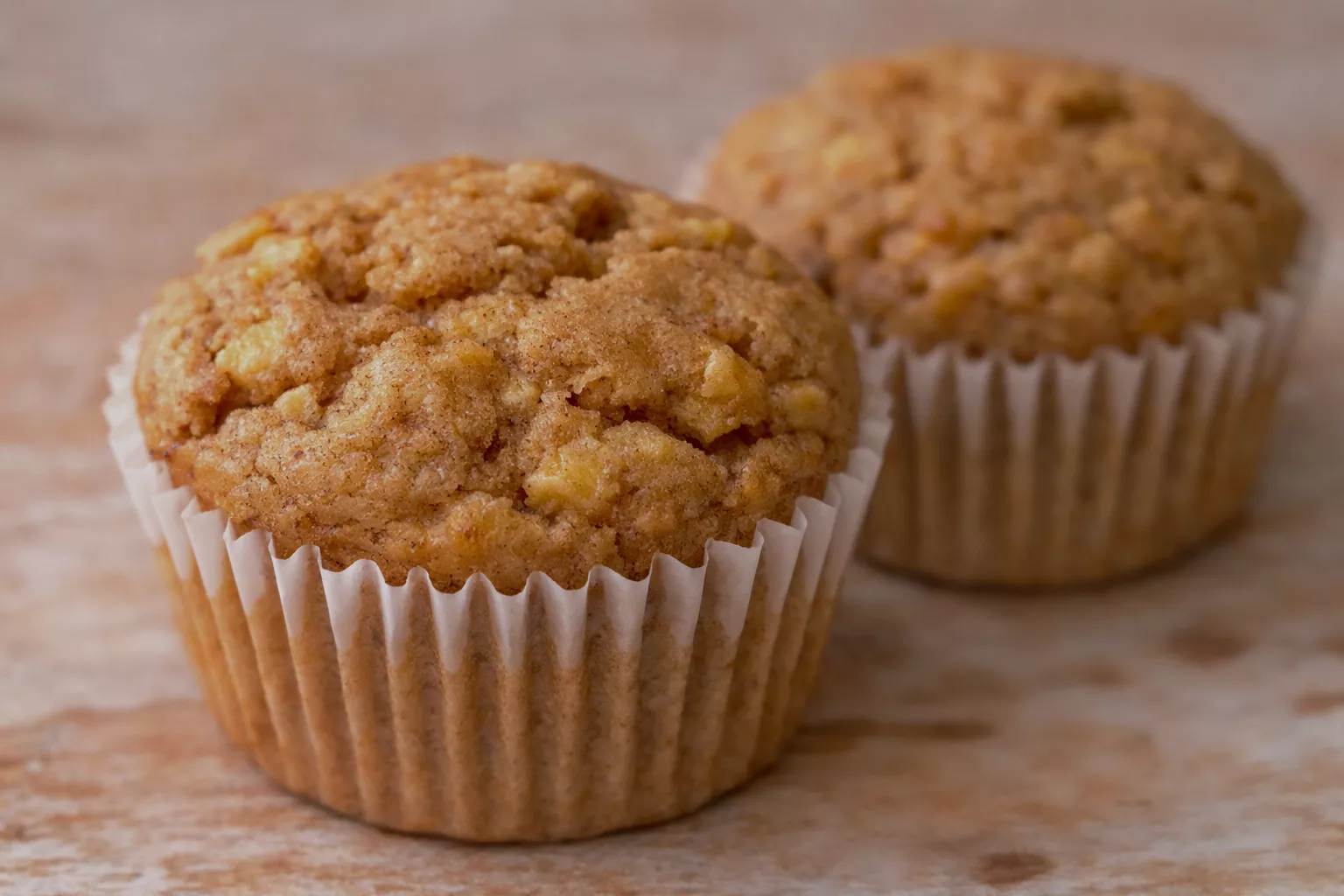 Two muffins sitting on a counter