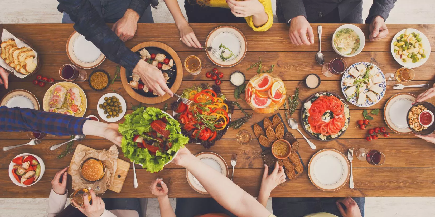 Group of people around a full dinner table.