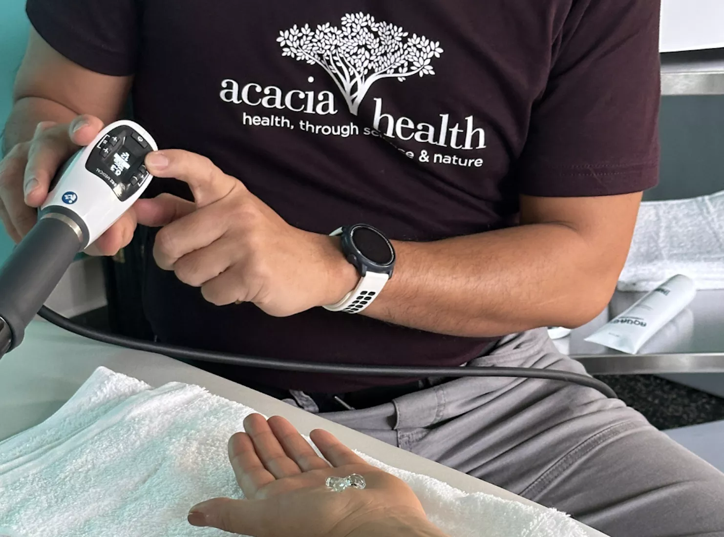 Physiotherapist demonstrating shockwave machine to a patient