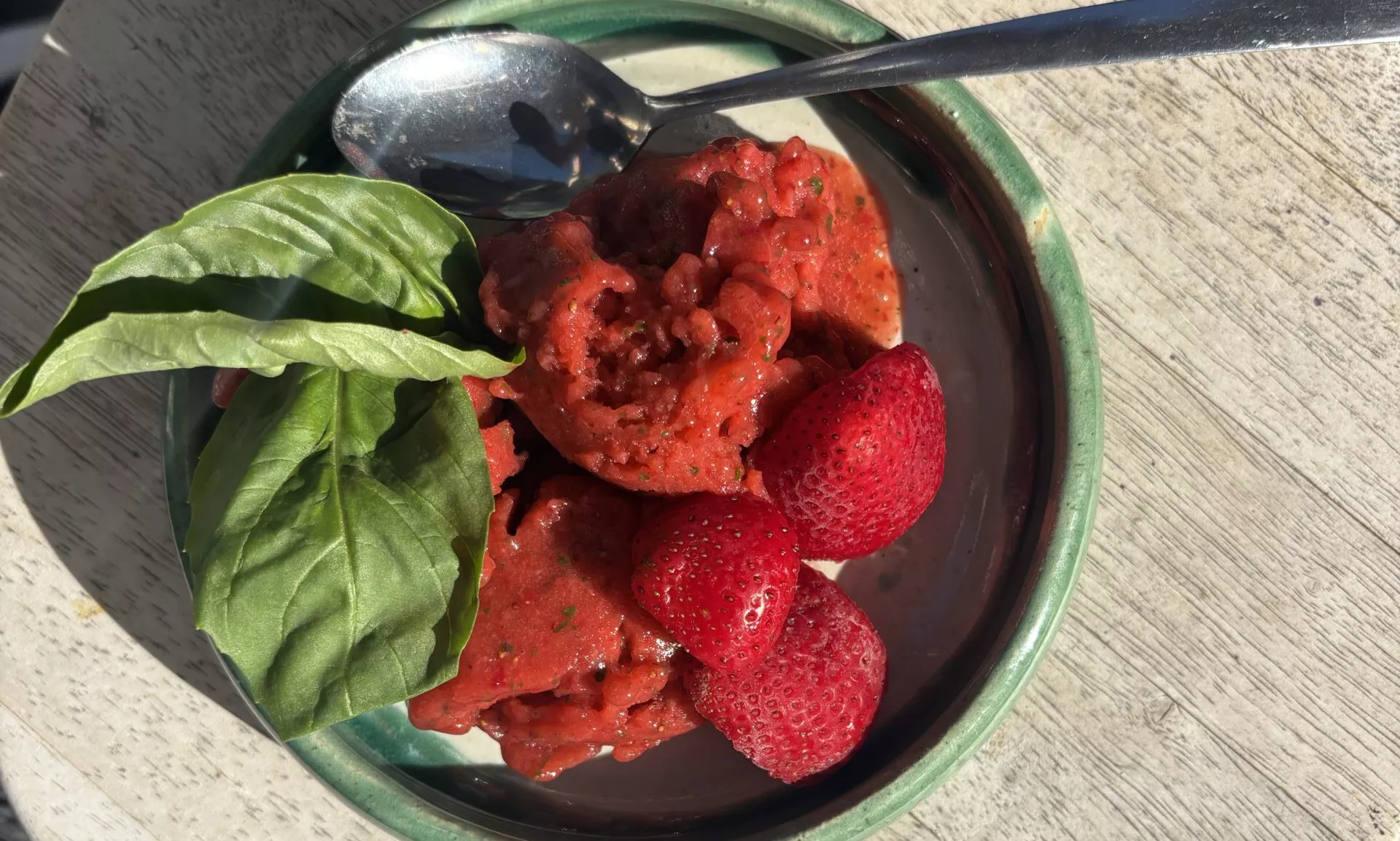 Bowl of strawberry sorbet with mint leaves on top
