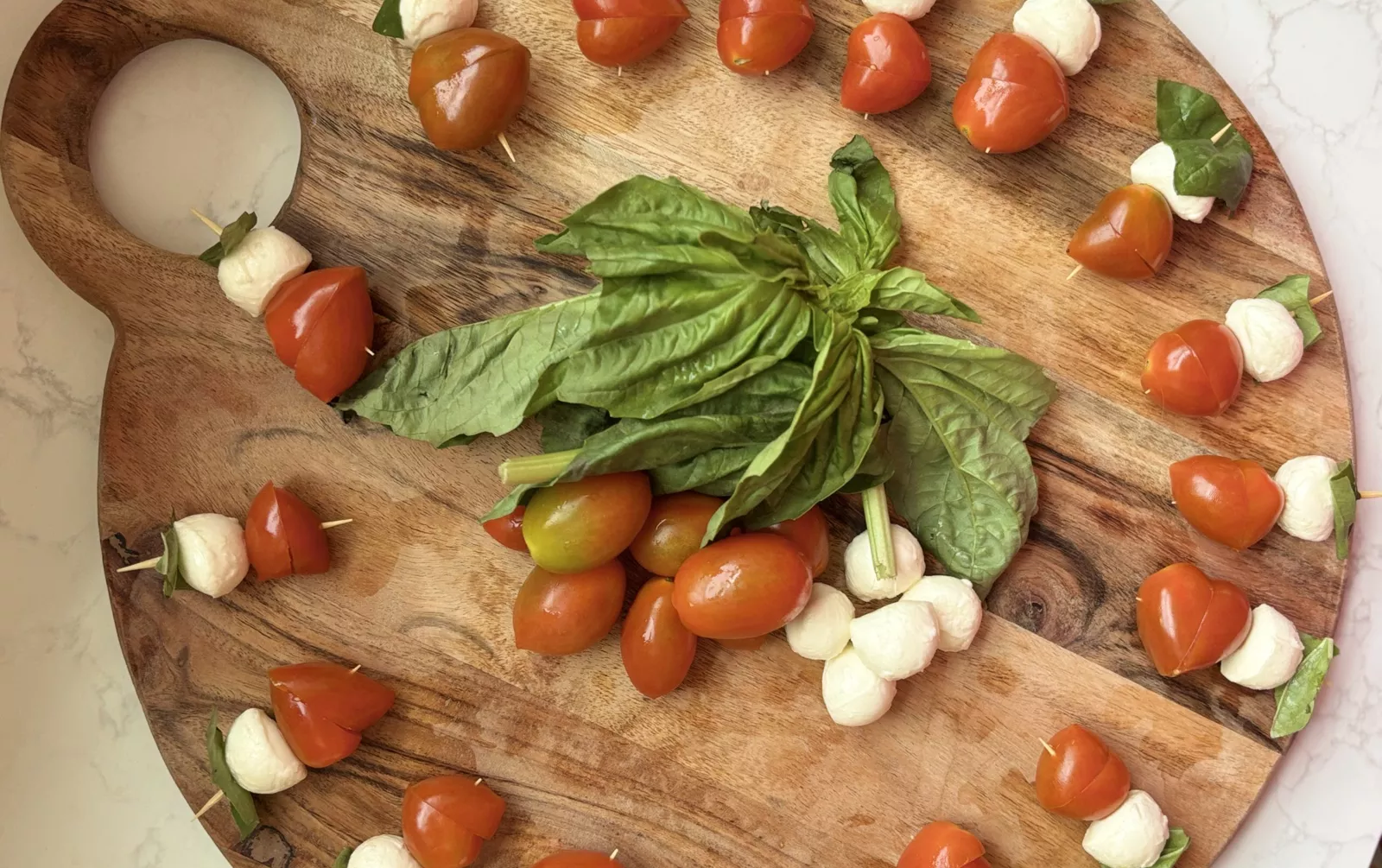 cutting board covered in Caprese salad bites