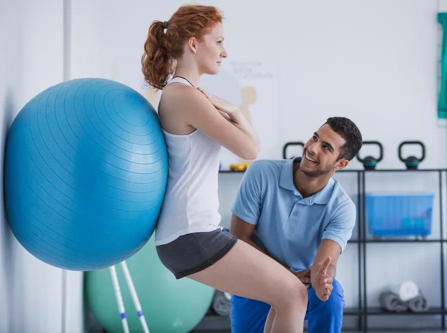 Physiotherapist showing exercises with a ball