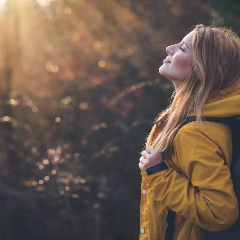 Person in the forest enjoying the sunshine